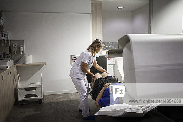 Reportage in einem Radiologiezentrum in Haute-Savoie  Frankreich. Ein Techniker führt eine Röntgenaufnahme des Knies eines Patienten mit beginnender Arthrose durch.