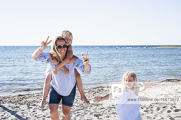 Mutter mit Töchtern am Strand
