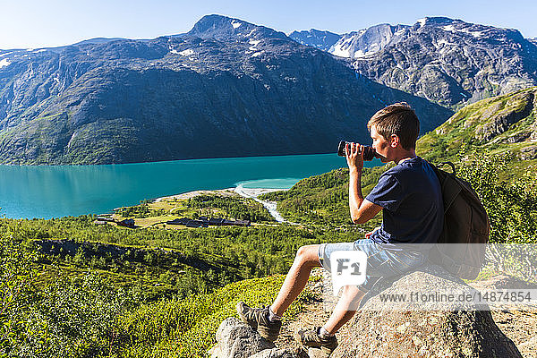 Boy sitting at lake