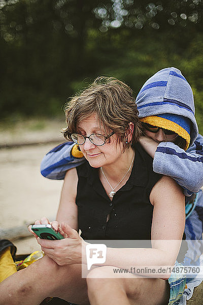 Frau benutzt Smartphone am Strand