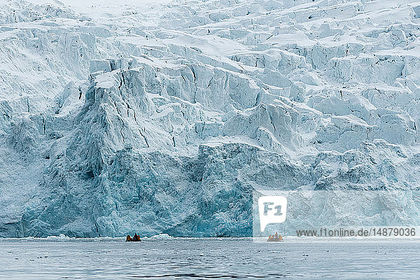 Touristen auf Schlauchbooten erkunden die polare Eiskappe nördlich von Spitzbergen  Norwegen