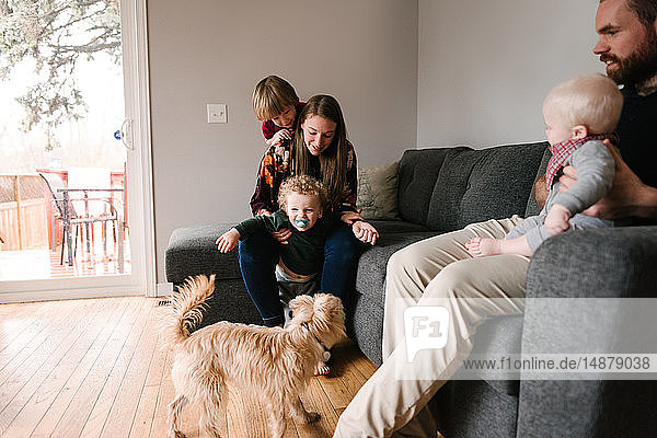 Familie und Söhne mit Haushund im Wohnzimmer
