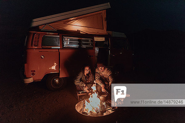 Junges Paar kocht nachts Lagerfeuer mit einem Wohnmobil  Jalama  Kalifornien  USA