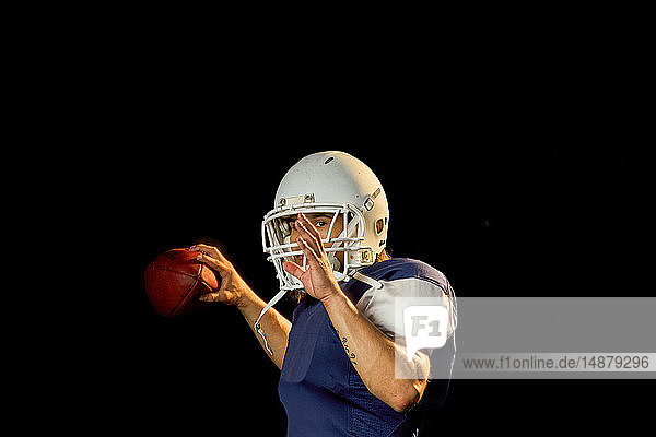 Porträt eines Quarterbacks mit Fussball  schwarzer Hintergrund