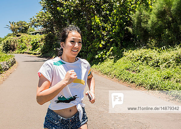 Frau läuft auf der Straße  Waipipi Trail  Maui  Hawaii