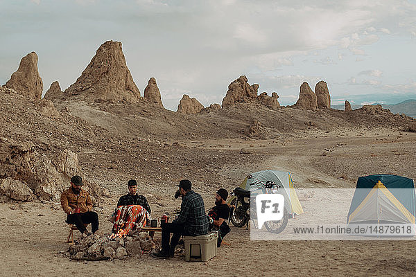 Motorcyclist road trippers around camp fire  Trona Pinnacles  California  US