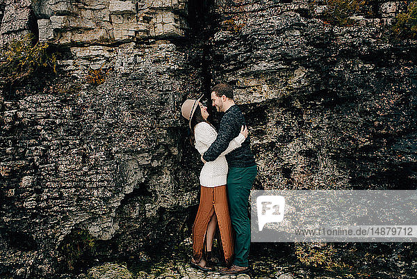 Couple hugging beside rock face  Tobermory  Canada