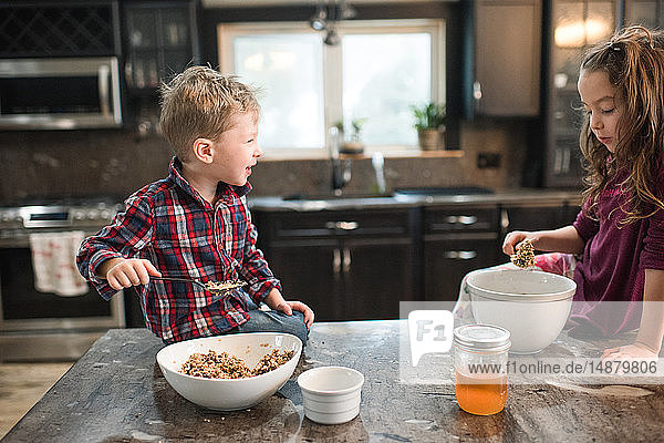 Kinder essen auf der Küchenarbeitsplatte