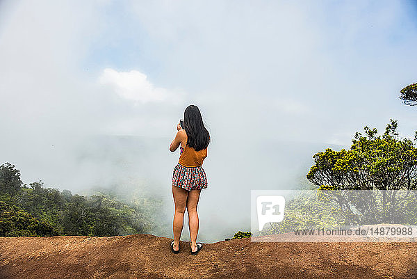 Woman taking photograph of mist  Waimea Canyon  Kauai  Hawaii
