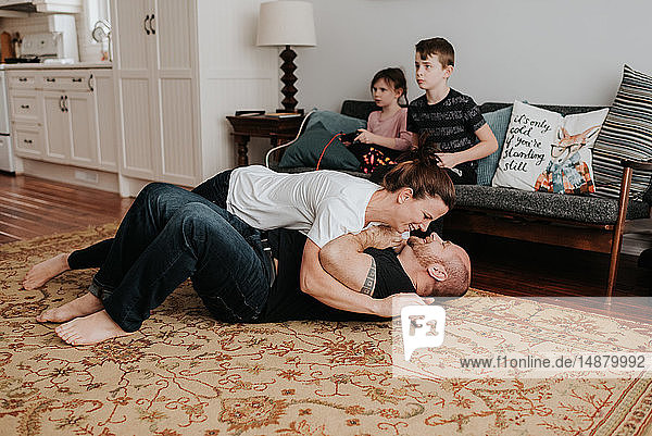 Children playing video game  parents wrestling at home