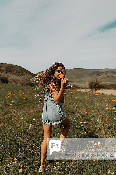 Junge Frau rennt im Feld der Wildblumen  Porträt  Jalama  Kalifornien  USA