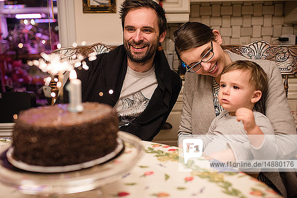 Couple and baby boy with first birthday cake