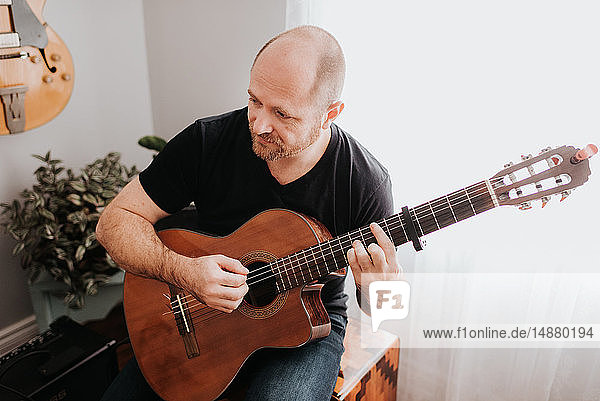 Mann spielt zu Hause Gitarre