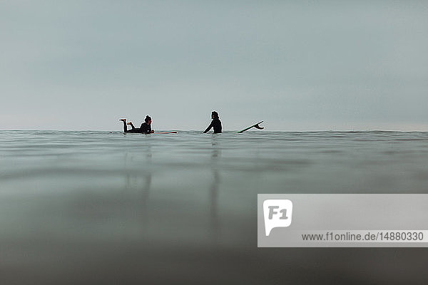 Junges Surferpaar mit Surfbrettern auf ruhiger,  nebliger See,  Ventura,  Kalifornien,  USA