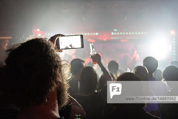 Mann fotografiert Konzert mit Smartphone