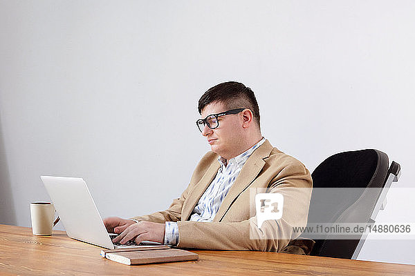 Mann arbeitet am Laptop im Heimbüro