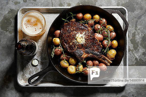 Pfanne mit großem Tomahawk-Steak & Kartoffeln  Draufsicht