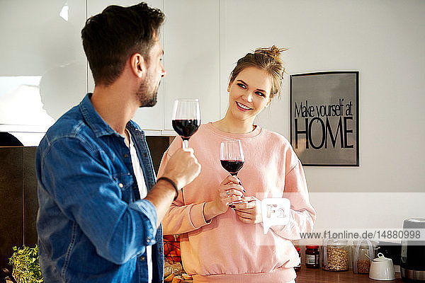 Paar redet und trinkt Rotwein in der Küche