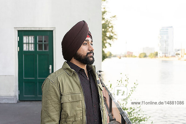 Indischer Mann erkundet Stadt  Fluss im Hintergrund  Berlin  Deutschland