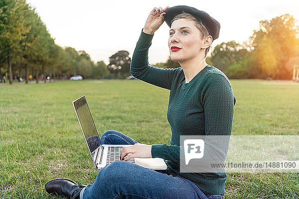Frau benutzt Laptop im Park