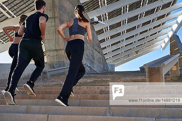 Freunde joggen Treppenstufen im Sportstadion hoch