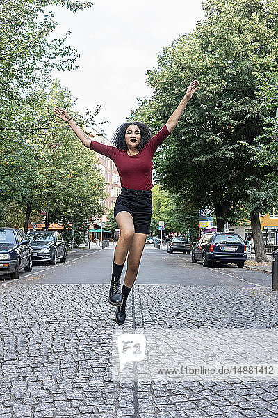 Junge Frau springt auf die Straße  Berlin  Deutschland
