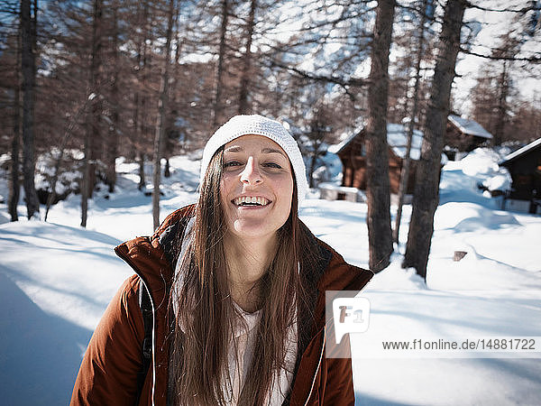 Junge Frau mit Strickmütze im verschneiten Wald  Porträt  Alpe Ciamporino  Piemont  Italien