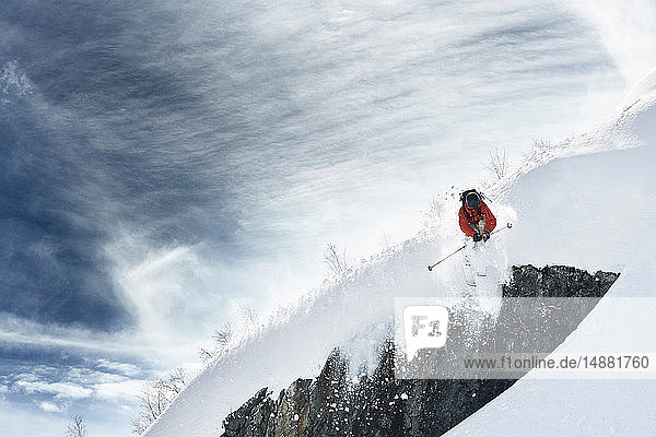 Männlicher Skifahrer beim Skifahren in der Luft  steiler schneebedeckter Berg  Alpe-d'Huez  Rhône-Alpes  Frankreich