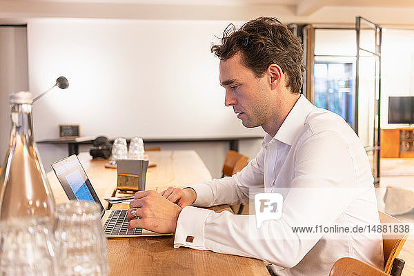 Mittlerer erwachsener Geschäftsmann beim Tippen am Laptop am Büroschreibtisch
