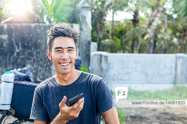 Mann benutzt Handy auf Autoreise  Pagudpud  Ilocos Norte  Philippinen