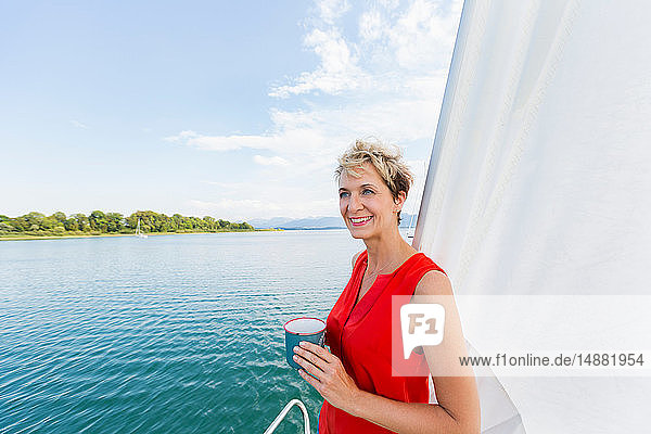 Mature woman having coffee while sailing on Chiemsee lake  Bavaria  Germany