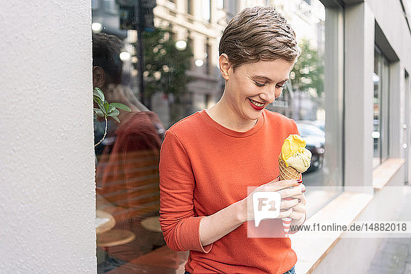 Frau isst Eiscreme vor dem Geschäft  Köln  Nordrhein-Westfalen  Deutschland