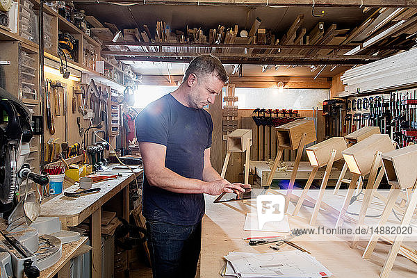 Designer using digital tablet by prototypes of table lamps
