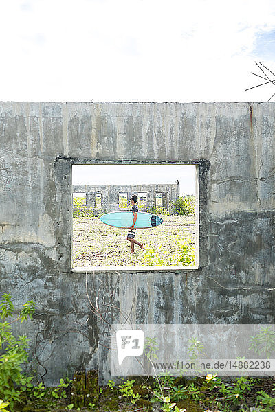 Surfer seen through window of abandoned building  Abulug  Cagayan  Philippines
