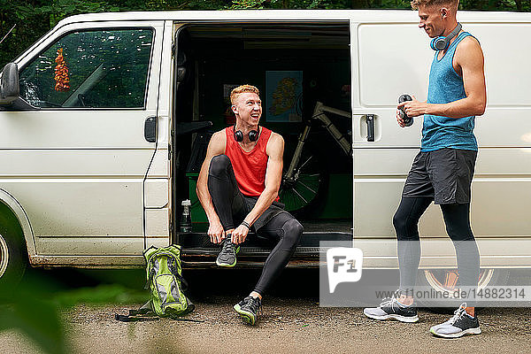 Runner friends talking beside van