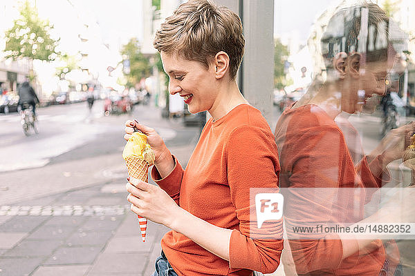Frau isst Eiscreme vor dem Geschäft  Köln  Nordrhein-Westfalen  Deutschland