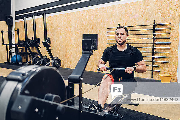 Mann mit Behinderung benutzt Rudergerät im Fitnessstudio
