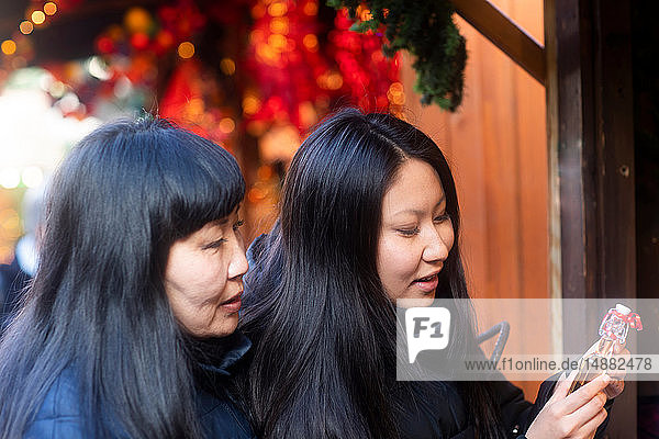Mutter und Tochter beim Schaufensterbummel auf dem Weihnachtsmarkt  Freiburg  Baden-Württemberg  Deutschland