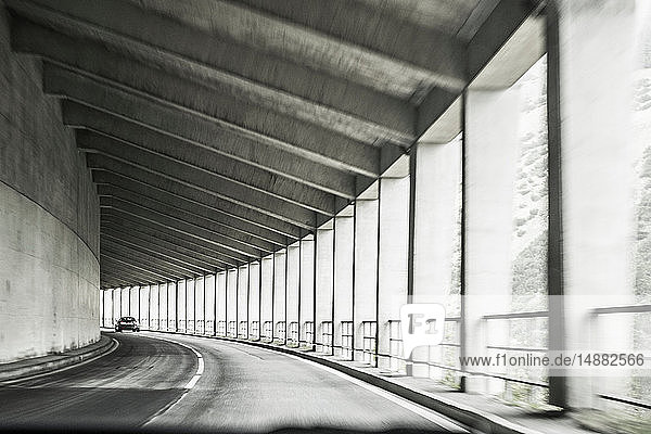 Autofahren durch eine überdachte Autobahn mit Pfeilern, Bozen, Trentino-Südtirol, Italien
