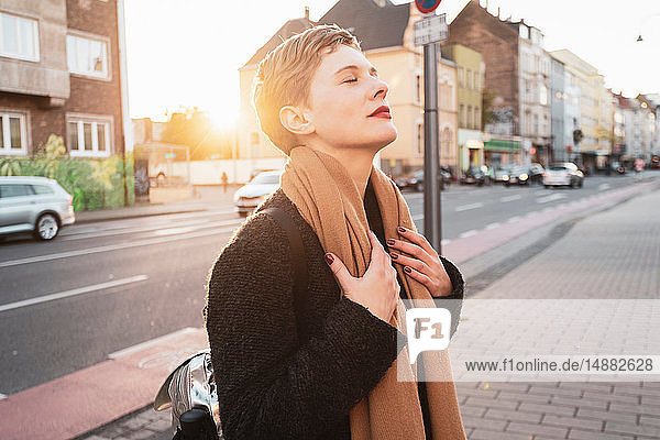 Frau mit geschlossenen Augen auf dem Bürgersteig  Köln  Nordrhein-Westfalen  Deutschland