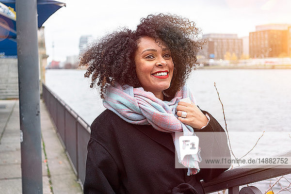 Mittelgroße erwachsene Frau mit Schal am Ufer der Spree  Berlin  Deutschland