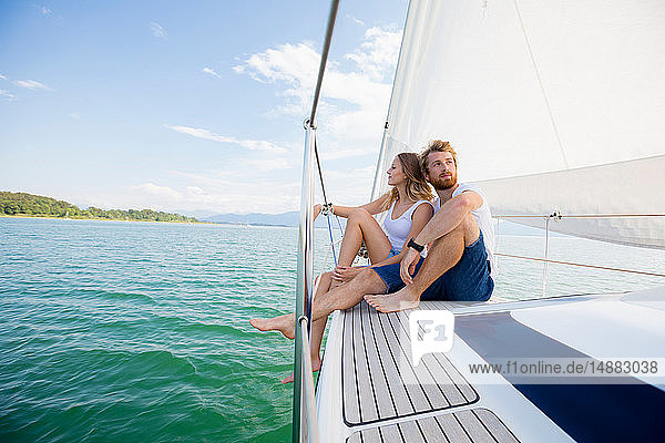 Young couple sailing on Chiemsee lake  Bavaria  Germany