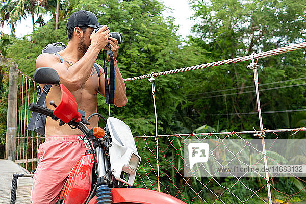Mann fotografiert auf Seilbrücke  Pagudpud  Ilocos Norte  Philippinen