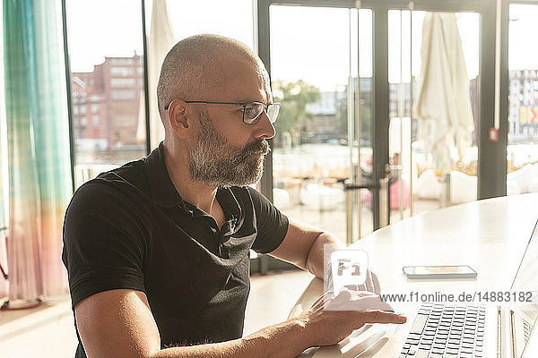 Mann benutzt Laptop im Büro an einem sonnigen Tag