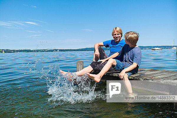 Vater und Sohn kühlen Füße im Wasser  Starnberger See  Bayern  Deutschland