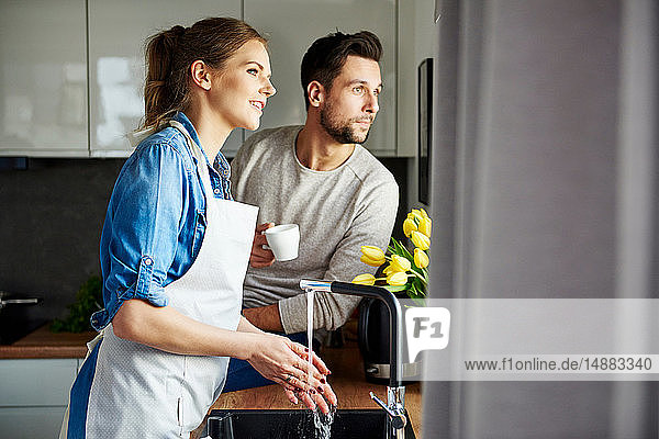 Paar  das Kaffee trinkt und in der Küche abspült