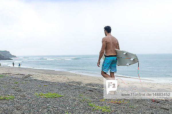 Surfer with surfboard on beach  Pagudpud  Ilocos Norte  Philippines