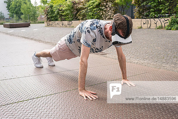 Mann in Push-up-Position mit Virtual-Reality-Brille Berlin Deutschland