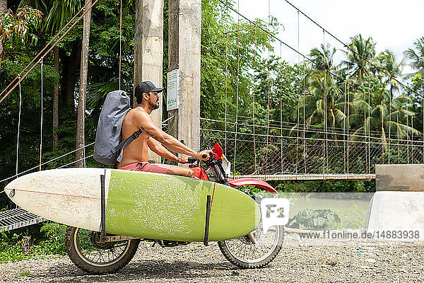 Motorradfahrer mit Surfbrett auf dem Fahrrad  Pagudpud  Ilocos Norte  Philippinen
