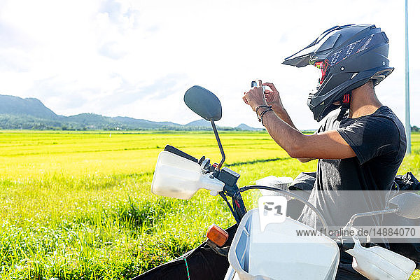 Motorcyclist stopping to take photograph  Camalaniugan  Cagayan  Philippines